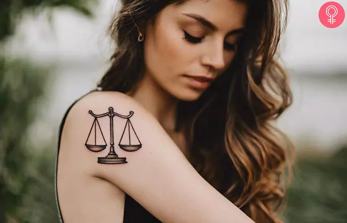 A woman with a Libra scale tattoo on her upper arm