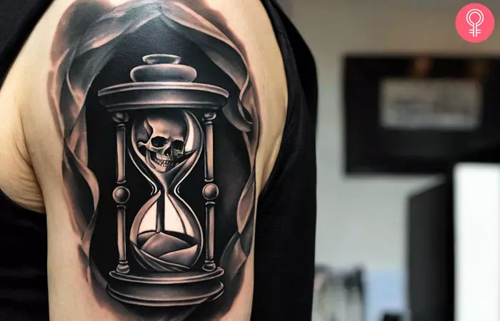 A man sporting a life and death skull hourglass tattoo on his upper arm