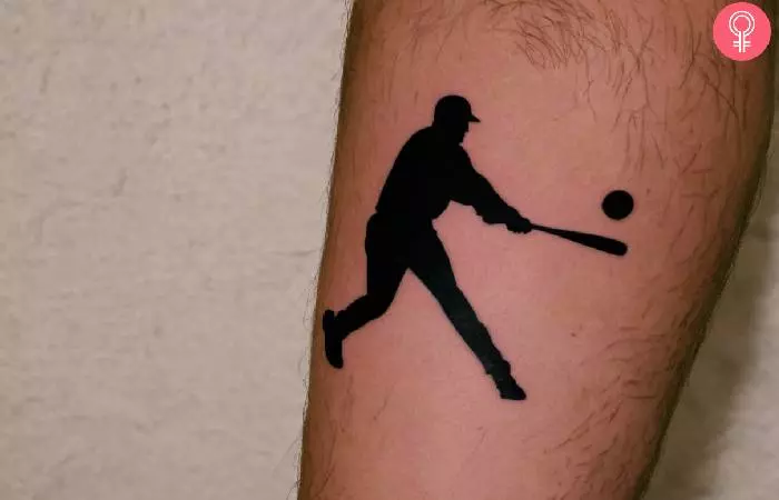 Man with a baseball player’s silhouette tattoo on the leg