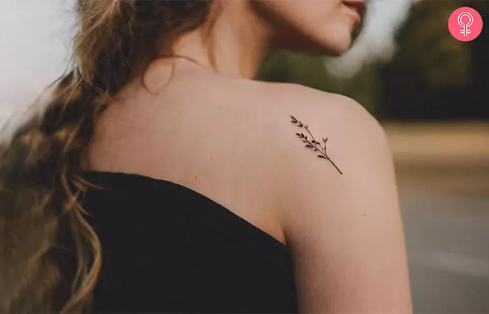 A minimalist twig growth tattoo on the shoulder