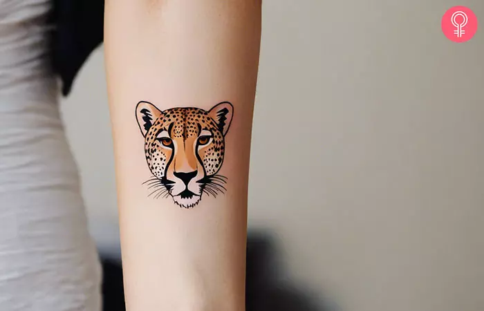 Minimalist cheetah tattoo on a woman’s arm