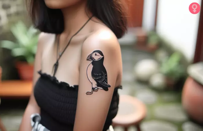 Minimalist puffin tattoo on a woman’s arm