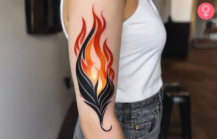 Woman with negative space flame tattoo on her arm