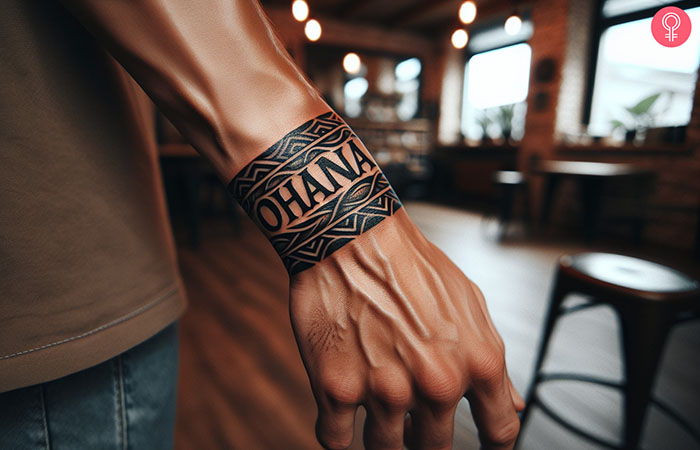 Ohana tattoo with tribal design on the hand of a man