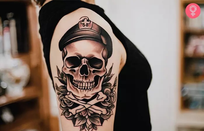 A woman with an old school skull and crossbones tattoo on her upper arm