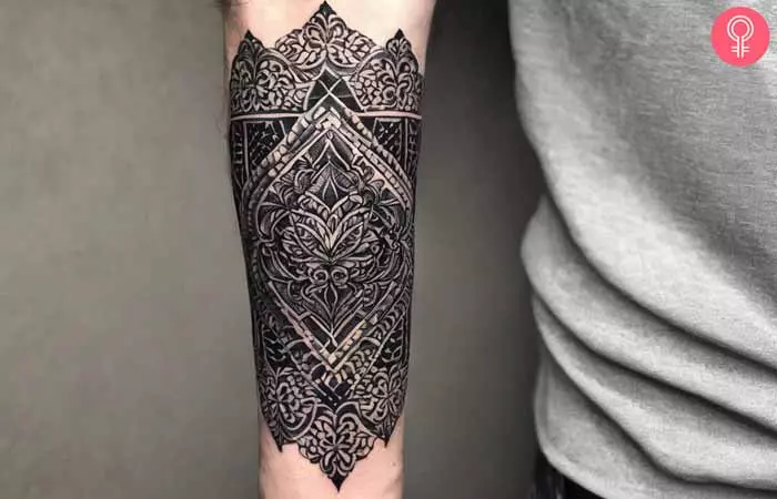 A man with an ornamental blackwork tattoo design on his arm 