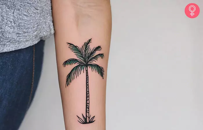 A palm tree forearm tattoo on a woman