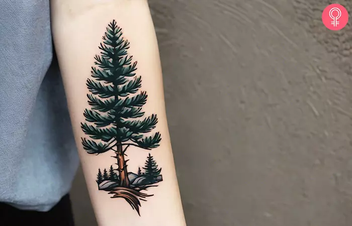 A pine tree forearm tattoo on a woman