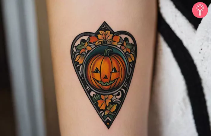 Planchette hand tattoo with a pumpkin