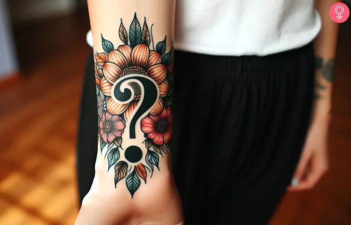 A question mark tattoo with flowers design on the wrist