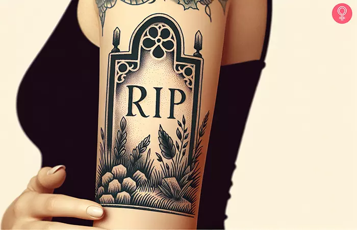 A RIP tombstone tattoo on the upper arm