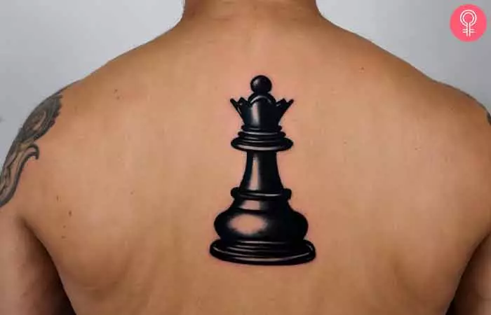 A pawn chess piece tattooed on the back of a man