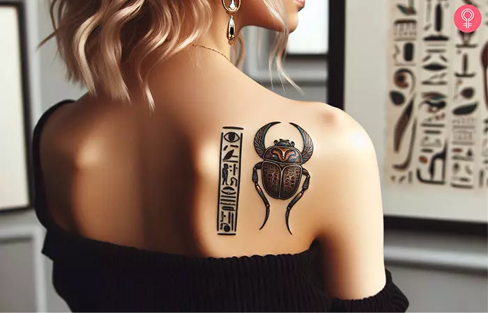 A scarab beetle with a minimalist hieroglyphics tattoo on the shoulder blade