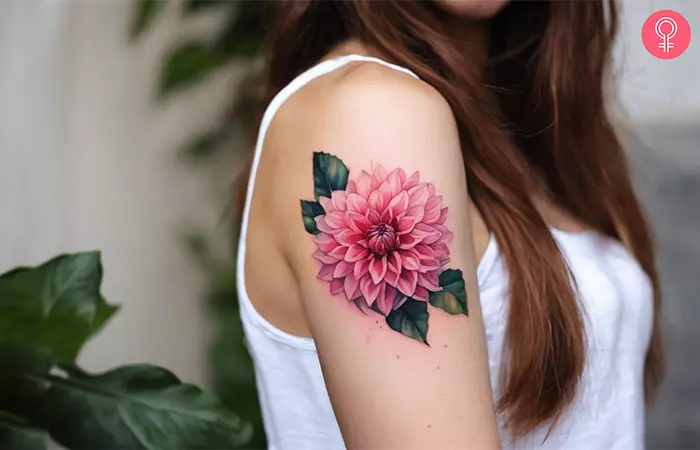 Pink dahlia growth tattoo on the upper arm