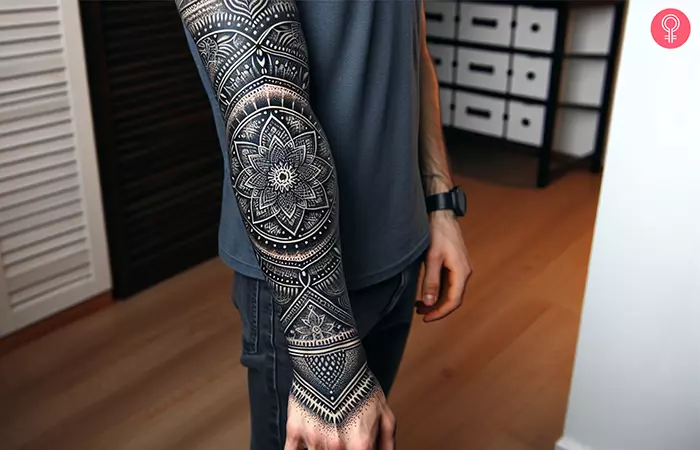 A negative space mandala blackout tattoo on the forearm