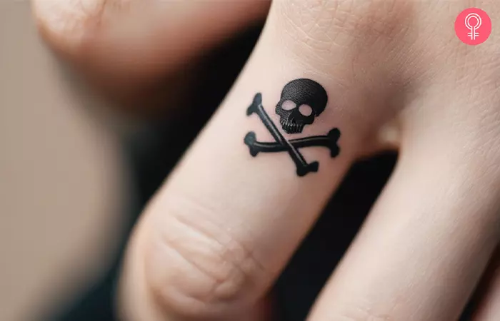 A woman with a skull and crossbones finger tattoo