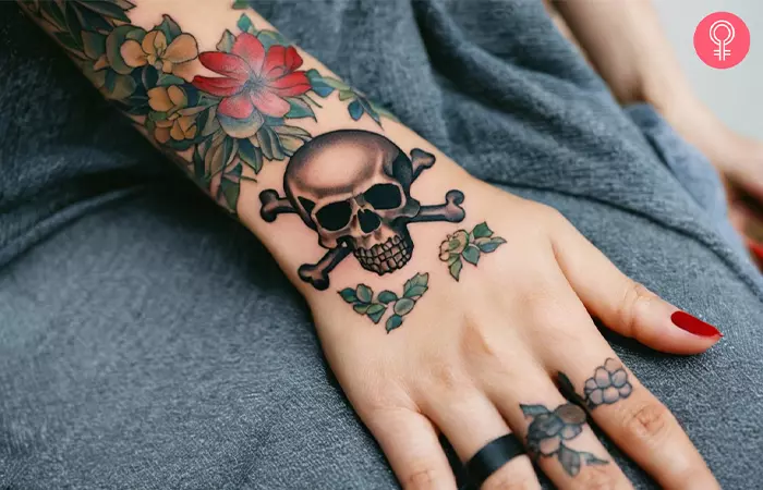 A woman with a skull and crossbones tattoo on her hand