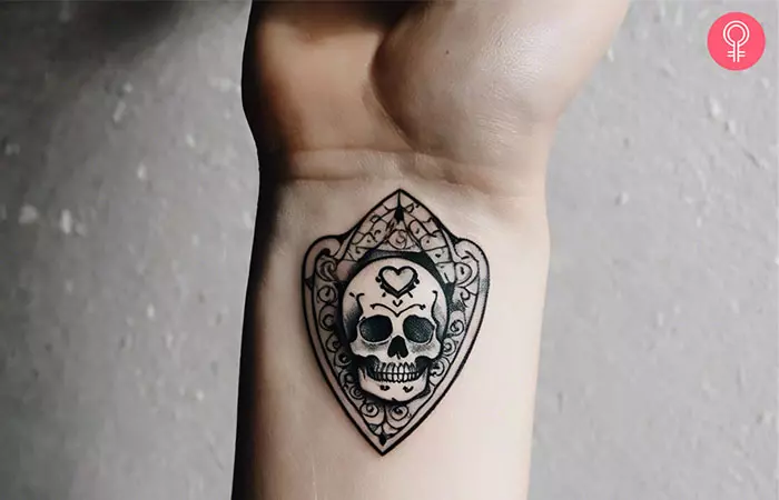 Skull planchette tattoo on a woman’s wrist