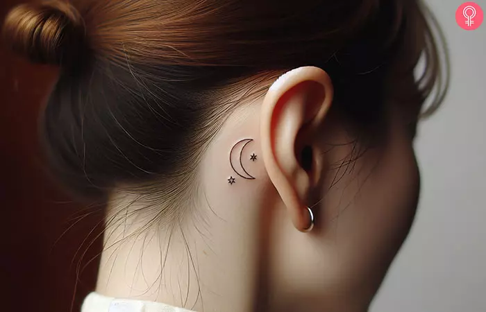 A crescent moon and star tattoo behind the ear