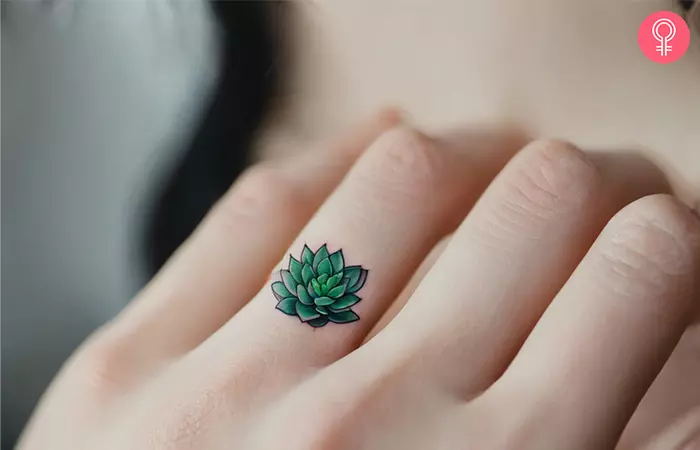 woman with small succulent tattoo on her finger