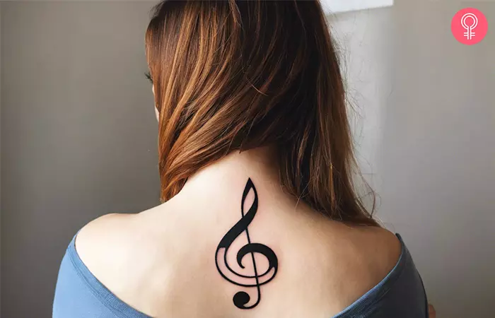 A woman with a solo treble clef tattoo on her back