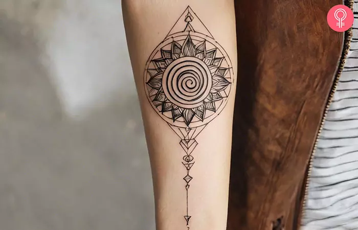 Spiral sun tattoo on the forearm