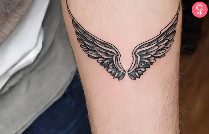 Spiritual guardian angel feather tattoo on the arm of a man