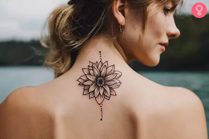 A woman with trippy stick and poke flower tattoo design on her back