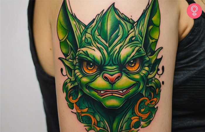 A woman with a stripe gremlin tattoo on her upper arm