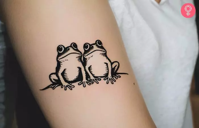 Tattoo of two frogs on a woman’s arm