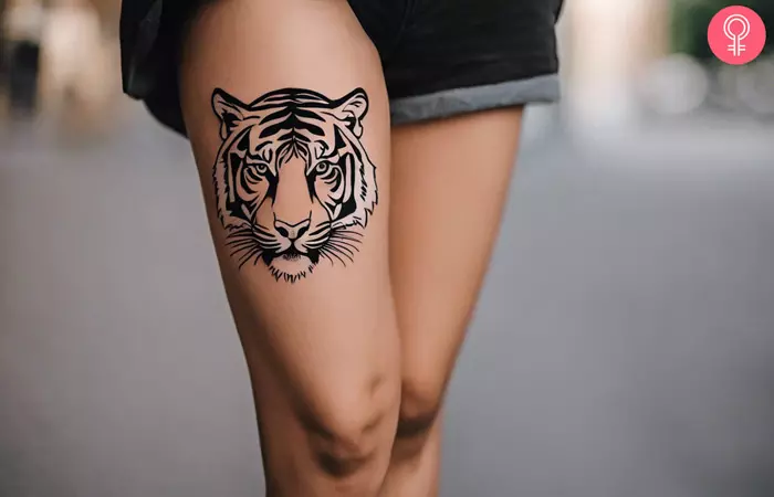 Woman with a tiger stripes tattoo on the thigh