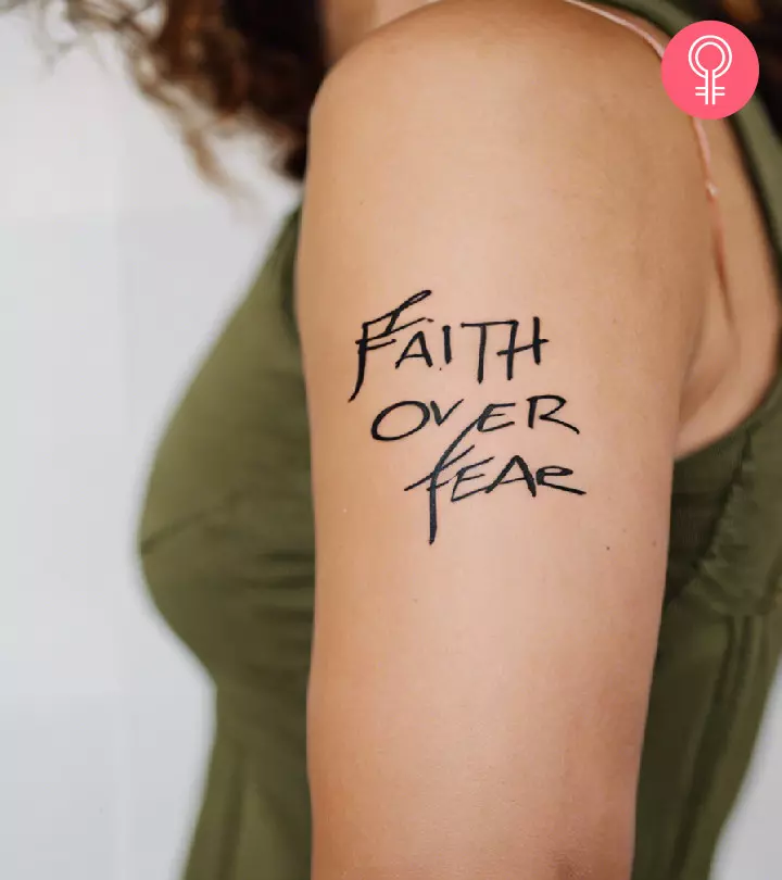 A faith over fear tattoo on a woman’s shoulder