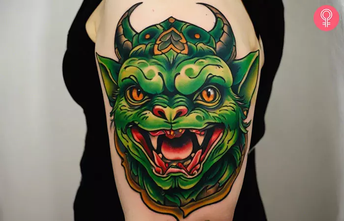 A woman with a traditional gremlin tattoo on her upper arm