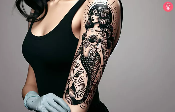 Woman with traditional mermaid tattoo on her upper arm