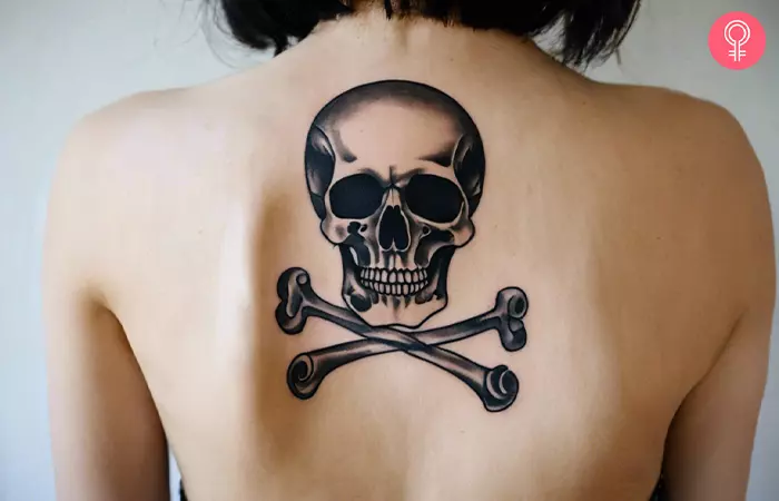 A woman with a traditional skull and crossbones tattoo on her back