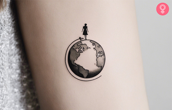 Travel tattoo of a girl on top of a globe