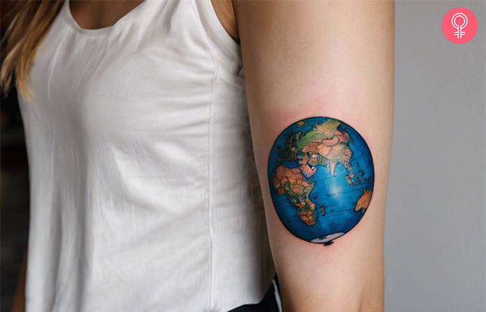 Travel tattoo of a globe on the upper arm