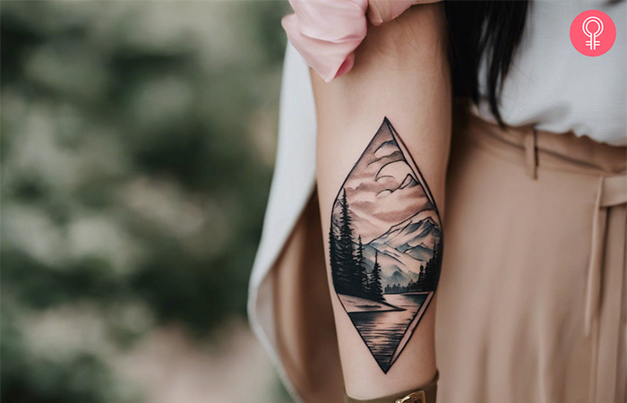 Travel tattoo of a landscape with mountains, trees, and a lake