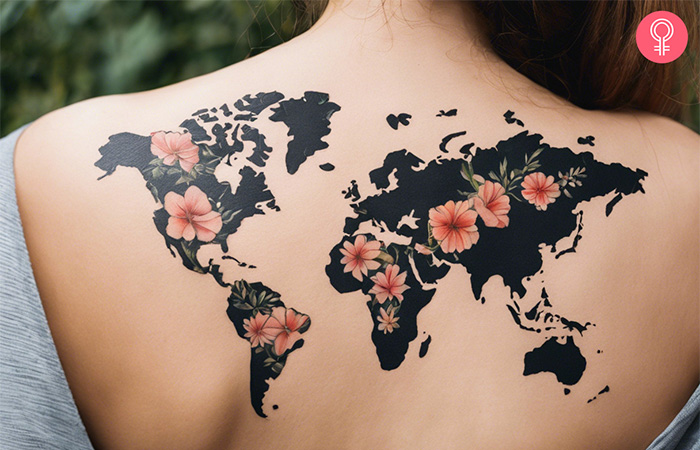 Travel tattoo of a world map decorated with flowers and leaves