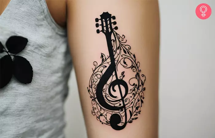 A woman with a treble clef guitar tattoo on her arm