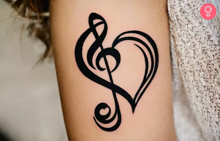 A woman with a treble clef heart tattoo on her arm