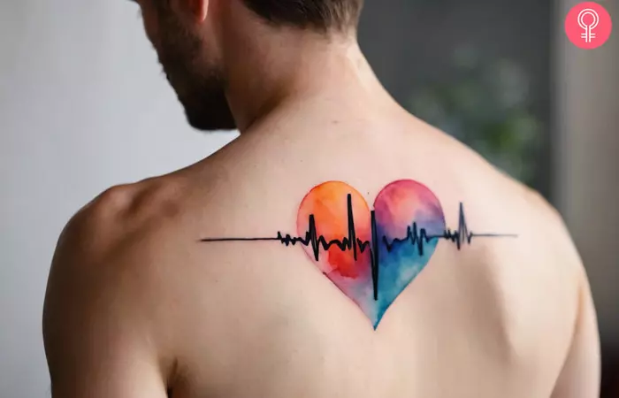 A man wearing a watercolor heartbeat tattoo on the back.