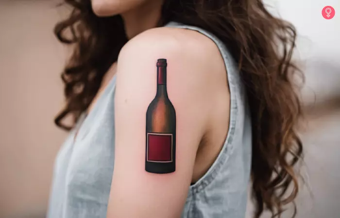 Wine bottle tattoo on the upper arm
