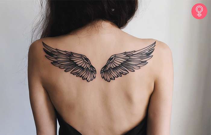A woman with a wings tattoo on her shoulder blades 