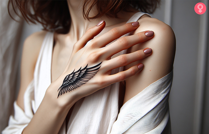 A woman with a wings tattoo design on the hand 