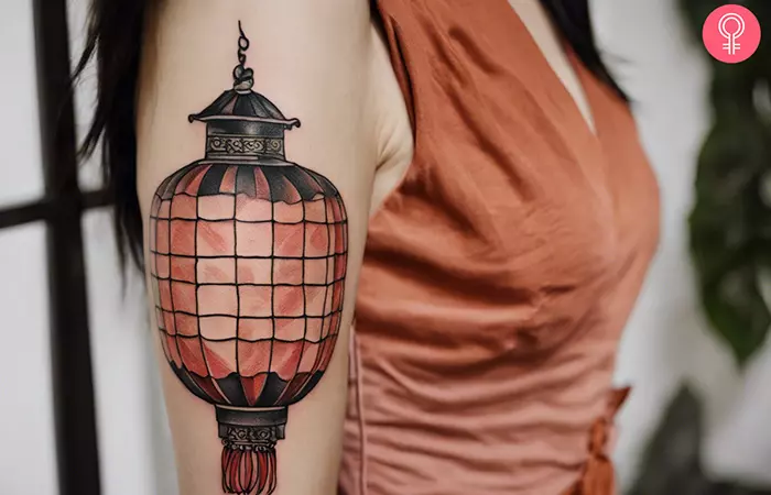 Woman with a Chinese lantern tattoo on the upper arm