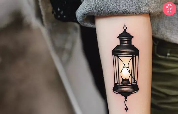 Woman with a broken lantern tattoo on the arm