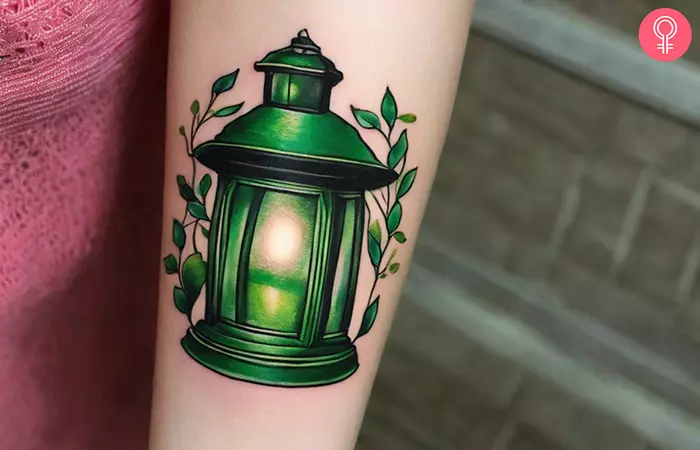 Woman with a green lantern tattoo on the forearm