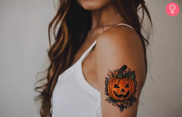 Woman with a jack-o’-lantern tattoo on the upper arm