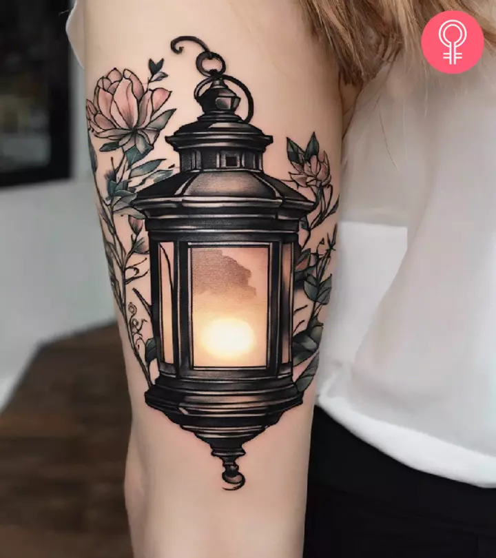 Woman with a lantern tattoo on the upper arm
